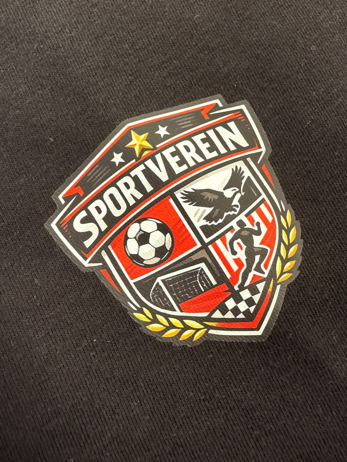 DTF-Transfer: mehrfarbiges Vereinswappen auf schwarzem Hoodie